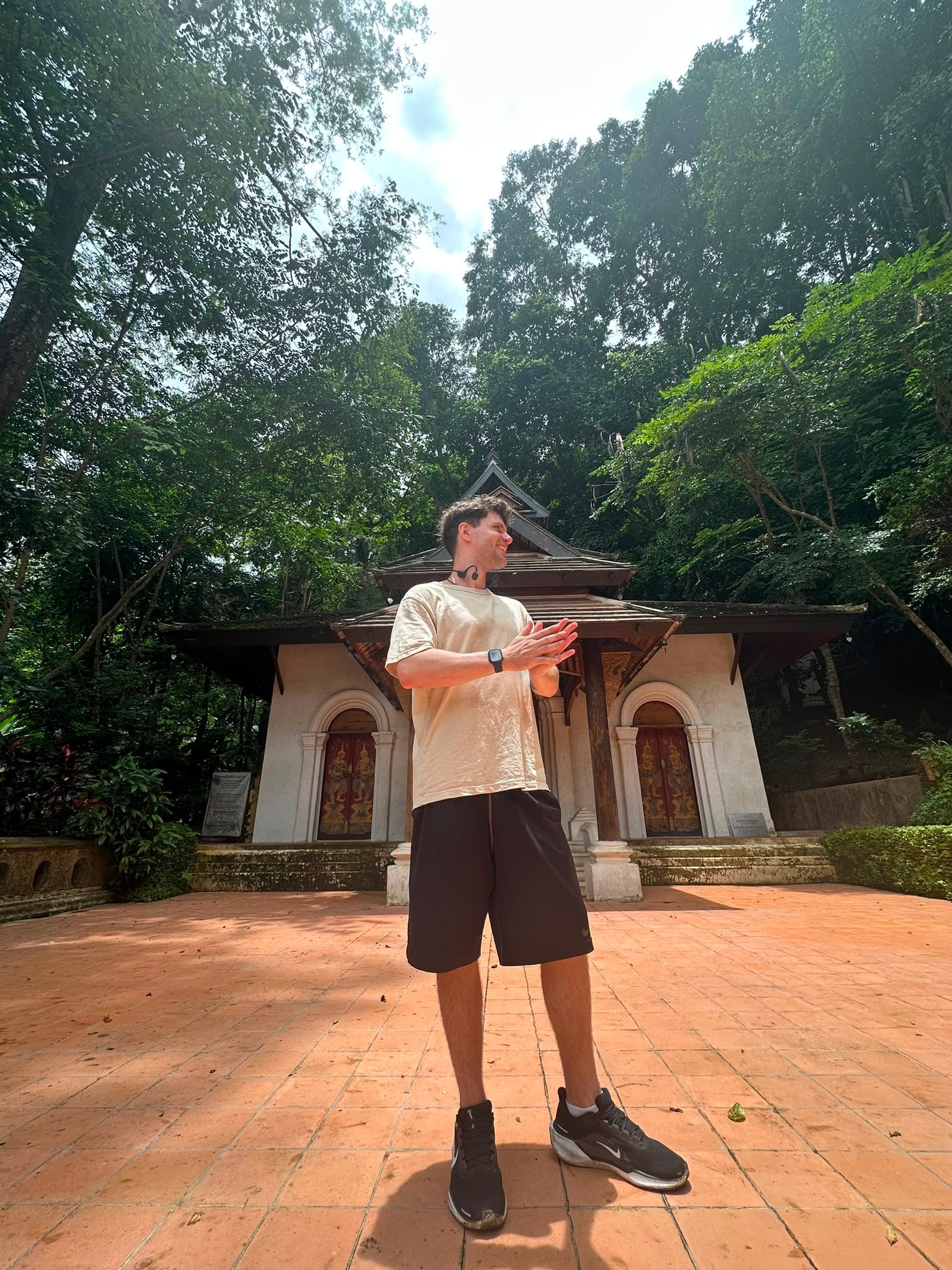 Standing in front of a small forest temple in the hills